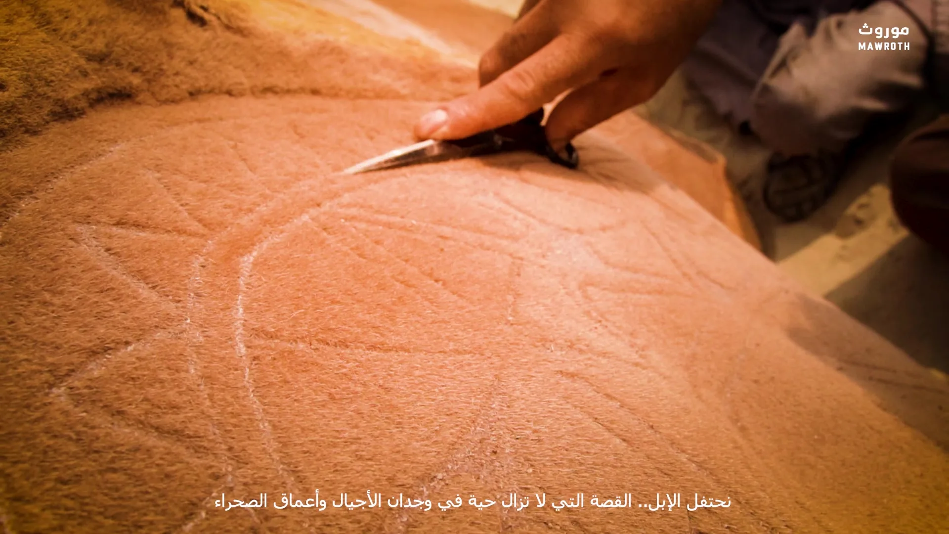 Overhead detail of camel engraving in progress — circular pattern with radiating lines carved into dense fur