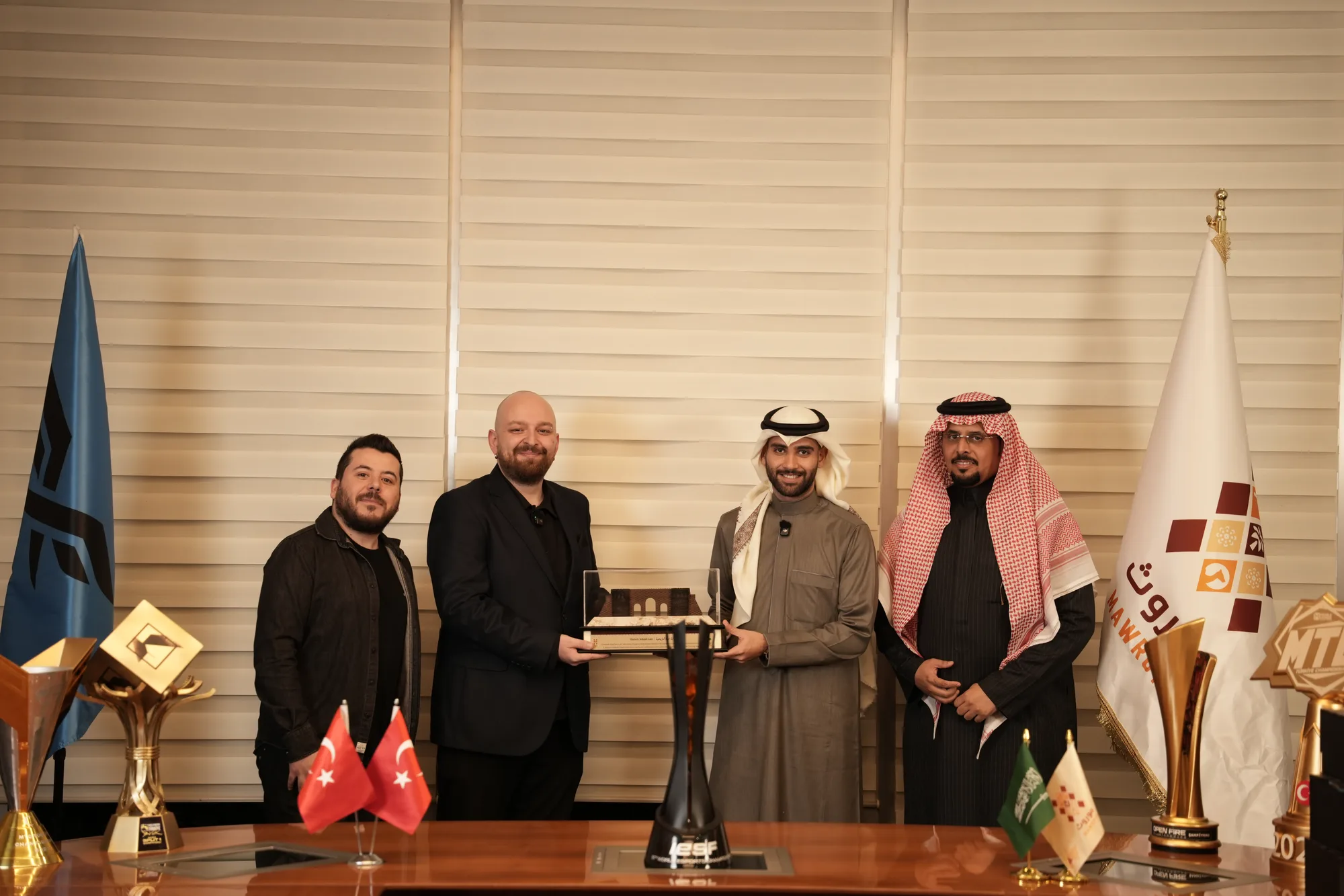 Four attendees present a commemorative plaque as part of the partnership ceremony