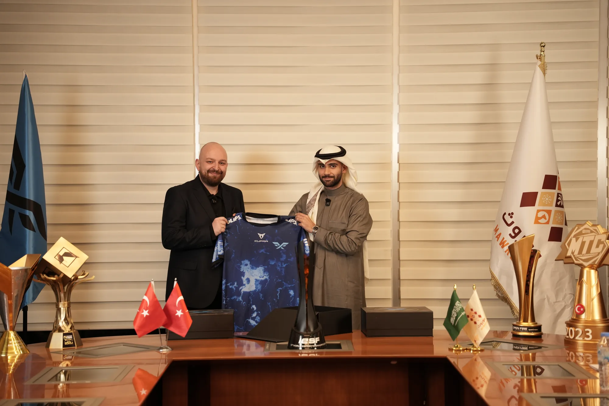 Fire Flux Esports representative and Mawroth signatory display a Fire Flux team jersey at the conclusion of the ceremony