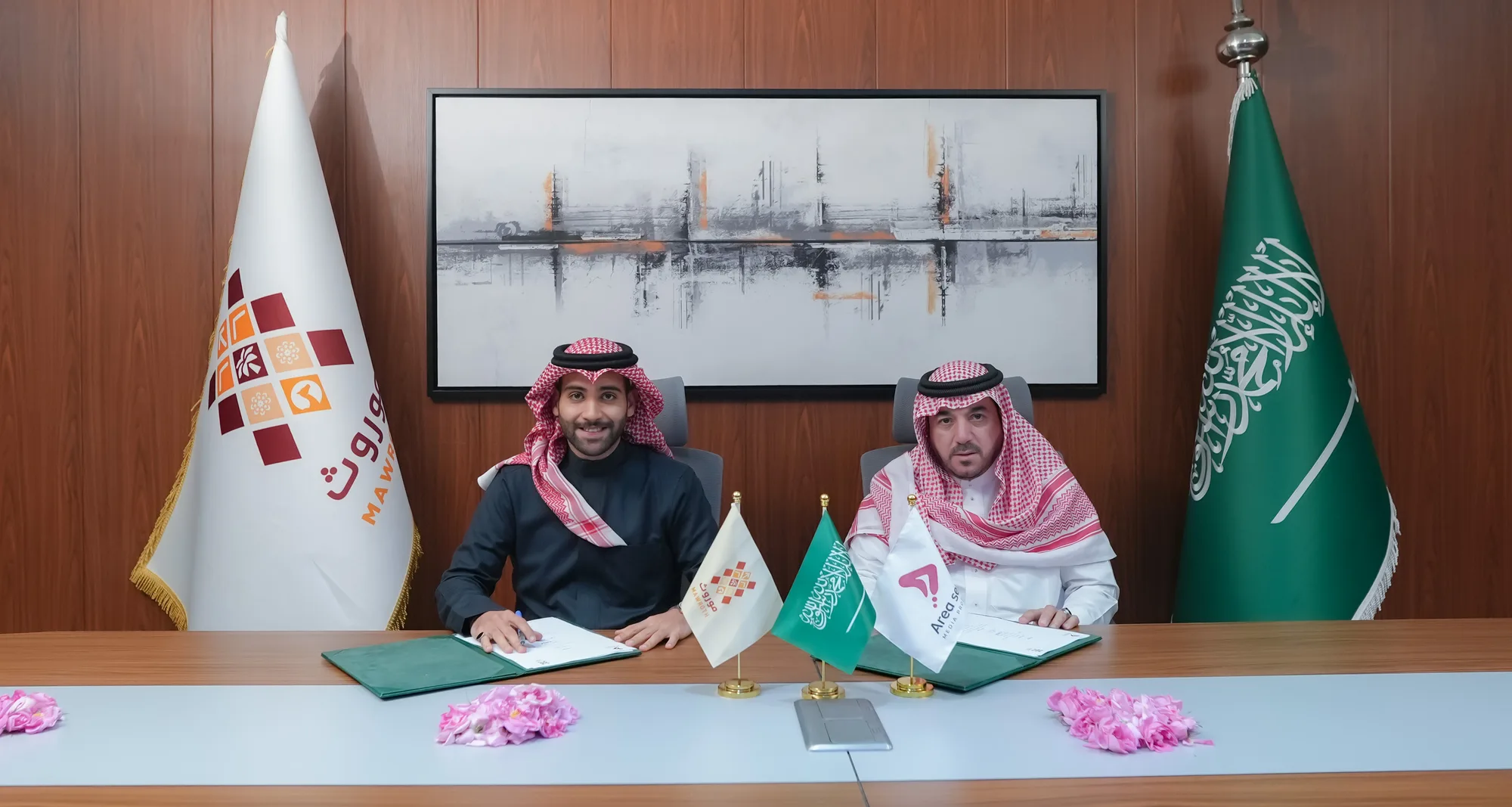 Mawroth CEO and Aria Seven representative seated at signing table, Mawroth banner flag visible, formalising the Nafas Program partnership agreement