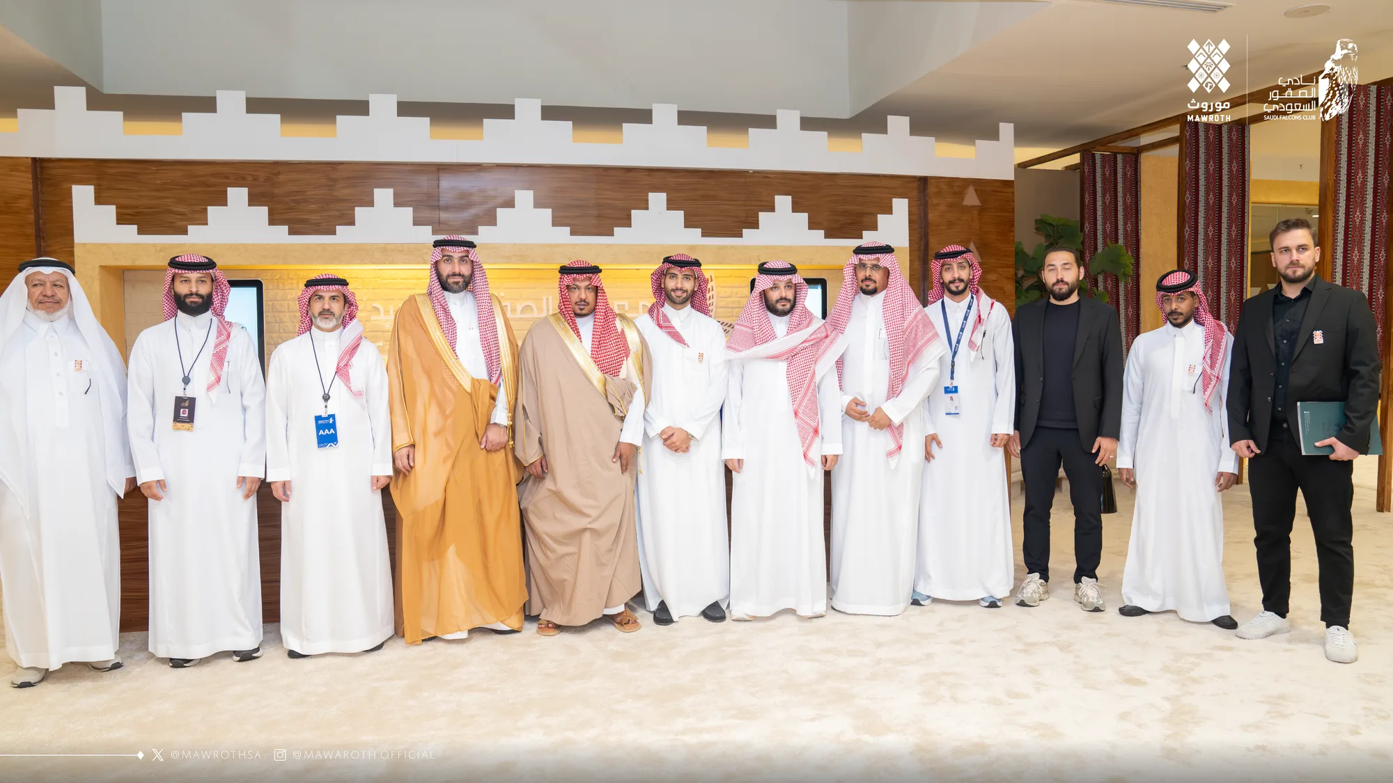Full group photo of Mawroth and Saudi Falcons Club representatives — twelve attendees lined up in the exhibition venue