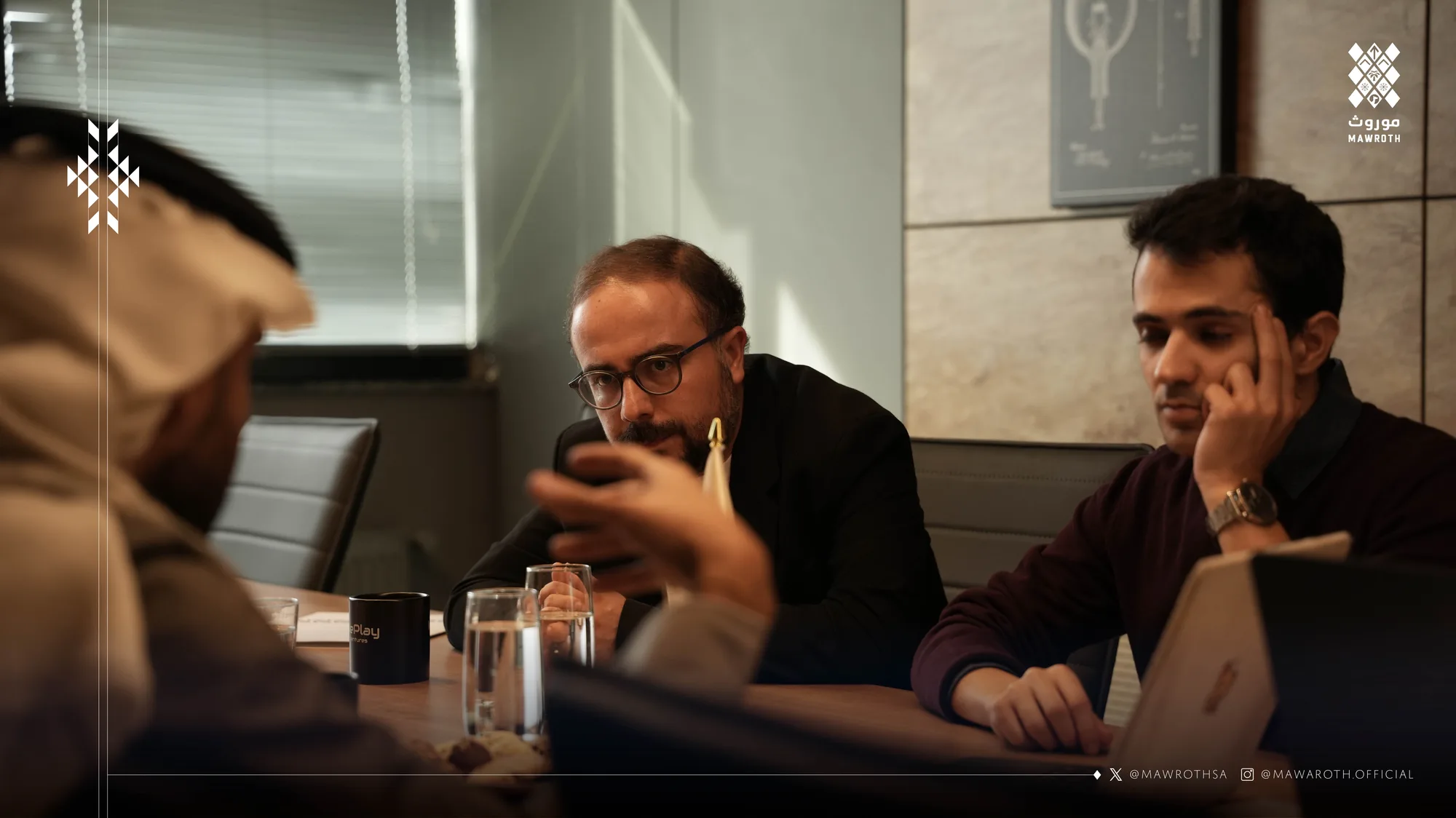 Three meeting participants reviewing content on a smartphone — an intimate working moment during the AI and VR partnership session
